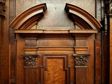 Düğümlenmiş desenler, mistik figürler ve yaşlı kereste yüzeyi üzerindeki yeşillik motifleri gibi tarihi dekoratif unsurları içeren ortaçağ Danimarka ahşap oymalarına yakından bakın..