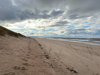 Sandy Aberlady Körfezi plajı. Doğu Lothian doğasında Firth of Forth nehri kıyısında. Uzak Forth Bridges ve Fife sahilleri bulutlu gökyüzü altında..