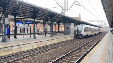 Polonya 'nın PKP yolcu trenleri Polonya' daki Gdansk Glowny ana istasyonuna girip çıkıyor, şehir merkezindeki rayları, platformları ve tarihi istasyon binalarını gösteriyor.