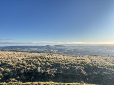 Yakındaki İskoç tepelerinden Glen Devon Vadisi 'ne, Glendevon rezervuarları, kıvrımlı nehir, Ochil Hills' in çimenli yamaçları ve aydınlık bir kış sabahı ormanlık alanlarının görüntüsü..
