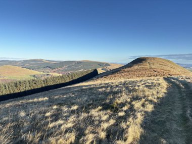 Yakındaki İskoç tepelerinden Glen Devon Vadisi 'ne, Glendevon rezervuarları, kıvrımlı nehir, Ochil Hills' in çimenli yamaçları ve aydınlık bir kış sabahı ormanlık alanlarının görüntüsü..