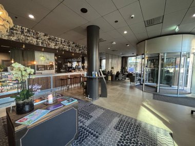 Helsingborg, İsveç 'teki otel lobisinin şık bir iç mekanı. Kayıt masası, bar tezgahı, rahat koltuklar ve gelen veya dinlenen misafirler için açık alan gösteriyor..