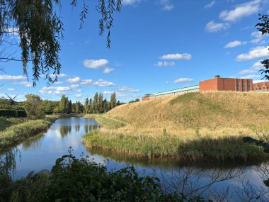 Malmhus Şatosu 'nun dış görünüşü, Malm İsveç' in İskandinavya 'daki en eski korunmuş Rönesans kalesi, taş cephe duvarları silindirik duvarlar, siperler, kemerli pencereler, kuru hendek erişim köprüsü bayrak direği ve bitişik park.