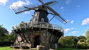 Slottsmllan, 1851 'de İsveç' teki Malm Kalesi 'ni çevreleyen Slottsparken parkında inşa edilen tarihi Hollanda tarzı yeldeğirmeni ahşap haç biçimli bıçakların, yapraksız akarsuların yakınındaki yüzey taşından aşınmış yapraksız ağaçlar göstermektedir.