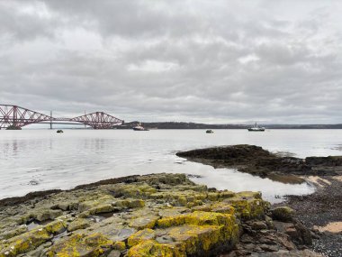 Forth Rail Bridge kantilever demiryolu manzarası İskoçya 'da geniş Forth of Forth halicileri boyunca uzanan çelik kiriş yapı kuleleri su yolları gökyüzü ve ufuk çizgisi boyunca uzanır.