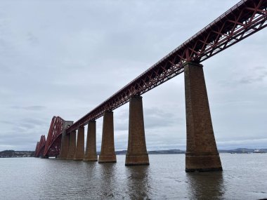 Forth Rail Bridge kantilever demiryolu manzarası İskoçya 'da geniş Forth of Forth halicileri boyunca uzanan çelik kiriş yapı kuleleri su yolları gökyüzü ve ufuk çizgisi boyunca uzanır.