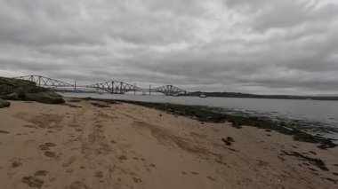 Forth Rail Bridge kantilever demiryolu manzarası İskoçya 'da geniş Forth of Forth halicileri boyunca uzanan çelik kiriş yapı kuleleri su yolları gökyüzü ve ufuk çizgisi boyunca uzanır.