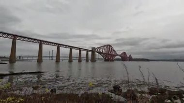 Forth Rail Bridge kantilever demiryolu manzarası İskoçya 'da geniş Forth of Forth halicileri boyunca uzanan çelik kiriş yapı kuleleri su yolları gökyüzü ve ufuk çizgisi boyunca uzanır.