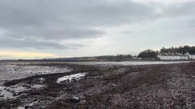 İskoçya 'nın dördüncü kıyı şeridi boyunca gelgit düzlükleri, hafif dalgalar, uzak köprüler ve kışın ufuk çizgisiyle birlikte..