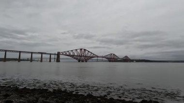 Forth Rail Bridge kantilever demiryolu manzarası İskoçya 'da geniş Forth of Forth halicileri boyunca uzanan çelik kiriş yapı kuleleri su yolları gökyüzü ve ufuk çizgisi boyunca uzanır.