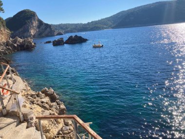 Yunanistan 'ın Korfu kentindeki Palaiokastritsa kentinin kıyı tepeleri, zeytin ağaçları, kayalık arazi ve adanın tipik Akdeniz bitkilerine sahip manzarası.