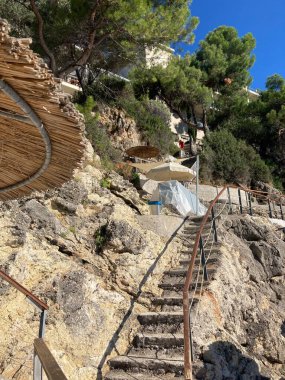 Yunanistan 'ın Korfu kentindeki Palaiokastritsa kentinin kıyı tepeleri, zeytin ağaçları, kayalık arazi ve adanın tipik Akdeniz bitkilerine sahip manzarası.
