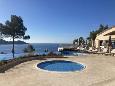 Yunanistan 'ın Korfu kentindeki Palaiokastritsa kentinin kıyı tepeleri, zeytin ağaçları, kayalık arazi ve adanın tipik Akdeniz bitkilerine sahip manzarası.