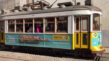 Lizbon şehir merkezindeki caddelerde faaliyet gösteren klasik klasik sarı tramvaylar. Portekiz 'in tarihi toplu taşımacılık bölgelerinden geçiyor.