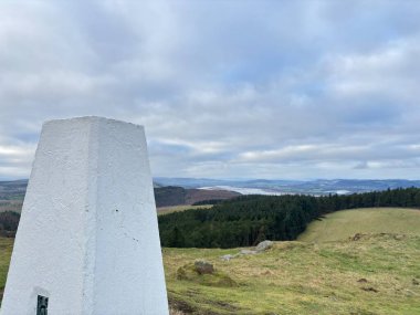 İskoçya 'nın Perthshire bölgesindeki Norman' s Law Tepesi 'nin zirvesinden panoramik kırsal manzaralar arasında trigonometri işaretleyicisi, taş cairn, yuvarlanan tepeler, vadiler ve açık manzara yer alıyor..