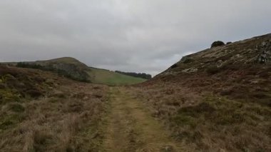 İskoçya 'nın Fife bölgesindeki tepe arazilerinde yürüyüş yaparken kayan tepeler, fundalıklar, yeşil alanlar, dağınık ağaçlar, açık manzaralar, uzak ufuklar ve doğal elementlerle tipik bir kır manzarası sergiliyoruz..