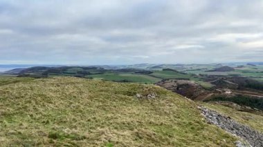 İskoçya 'nın Fife bölgesindeki Norman' s Law Tepesi 'nin zirvesinden panoramik manzara perspektifleri tipik bir kır manzarasını gösteriyor. Tepeler, fundalıklar, yeşil alanlar, dağınık ağaçlar, açık manzaralar, Tay' in Firth of Tay.