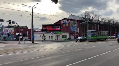 Polonya 'daki Elblag şehir merkezinden geçen sokak tramvayları şehir sokaklarında toplu taşımacılık sahnesini gösteren elektrik hatları ve raylar üzerinde.