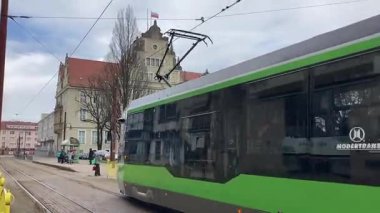 Polonya 'daki Elblag şehir merkezinden geçen sokak tramvayları şehir sokaklarında toplu taşımacılık sahnesini gösteren elektrik hatları ve raylar üzerinde.