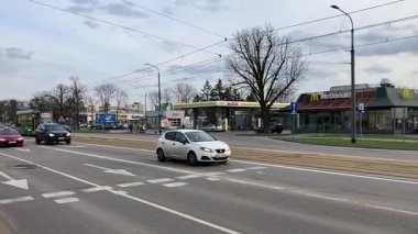 Polonya 'daki Elblag şehir merkezinden geçen sokak tramvayları şehir sokaklarında toplu taşımacılık sahnesini gösteren elektrik hatları ve raylar üzerinde.