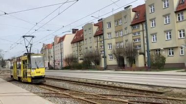 Polonya 'daki Elblag şehir merkezinden geçen sokak tramvayları şehir sokaklarında toplu taşımacılık sahnesini gösteren elektrik hatları ve raylar üzerinde.