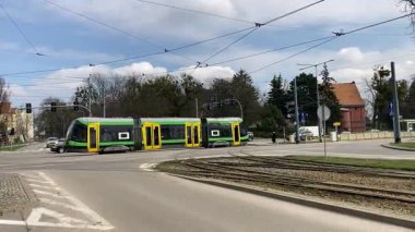 Polonya 'daki Elblag şehir merkezinden geçen sokak tramvayları şehir sokaklarında toplu taşımacılık sahnesini gösteren elektrik hatları ve raylar üzerinde.