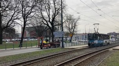 Polonya 'daki Elblag şehir merkezinden geçen sokak tramvayları şehir sokaklarında toplu taşımacılık sahnesini gösteren elektrik hatları ve raylar üzerinde.