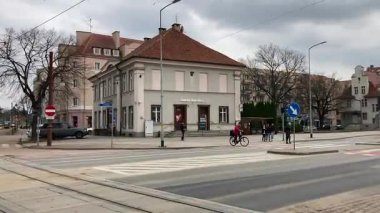 Polonya 'daki Elblag şehir merkezinden geçen sokak tramvayları şehir sokaklarında toplu taşımacılık sahnesini gösteren elektrik hatları ve raylar üzerinde.