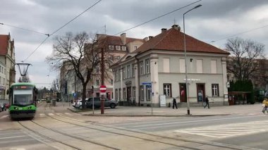 Polonya 'daki Elblag şehir merkezinden geçen sokak tramvayları şehir sokaklarında toplu taşımacılık sahnesini gösteren elektrik hatları ve raylar üzerinde.