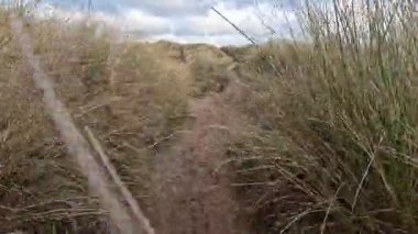 Fırtınalı bir günde İngiltere 'nin Northumberland kentindeki Bamburgh yakınlarındaki Ross Sands plajında dalgalı dalgalarla dalgalı deniz ve kara bulutlar..