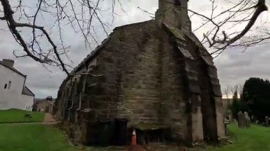 Bellingham 'daki Aziz Cuthbert Kilisesi' nin dışı geleneksel taş yapısını, tarihi kilise mimarisini ve İngiltere 'deki sessiz köy çevresini gösteriyor..