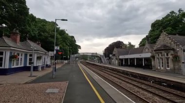 Highland ana hattındaki Pitlochry tren istasyonunda taş yapı platformları İskoçya 'nın kırsal kesimindeki demir köprü.