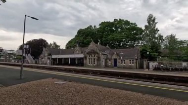 Highland ana hattındaki Pitlochry tren istasyonunda taş yapı platformları İskoçya 'nın kırsal kesimindeki demir köprü.