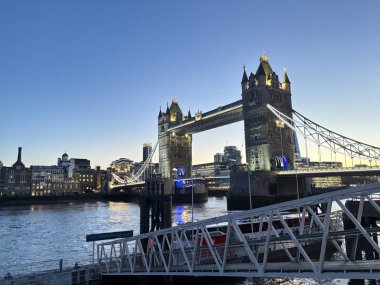 Londra, İngiltere 'deki Thames nehrinin üzerinde geceleyin aydınlanan Tower Bridge' de baskül açıklığı, asma kablolar, neo-gotik kuleler ve üst düzey yürüyüş yolları yer alıyor..