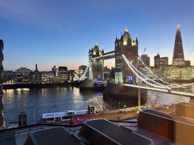 Londra, İngiltere 'deki Thames nehrinin üzerinde geceleyin aydınlanan Tower Bridge' de baskül açıklığı, asma kablolar, neo-gotik kuleler ve üst düzey yürüyüş yolları yer alıyor..
