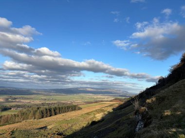 İskoçya 'nın Stirling' in batısındaki Gargunnock Hills 'de kaygan yamaç manzaraları, yamaç, volkanik kaya ve dereye bakan panoramik manzaralar.
