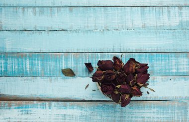 Mavi ahşap üzerine kurutulmuş güller yürekten