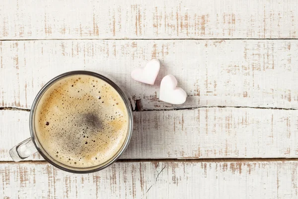 hot morning coffee with two heart shaped marshmallows on white