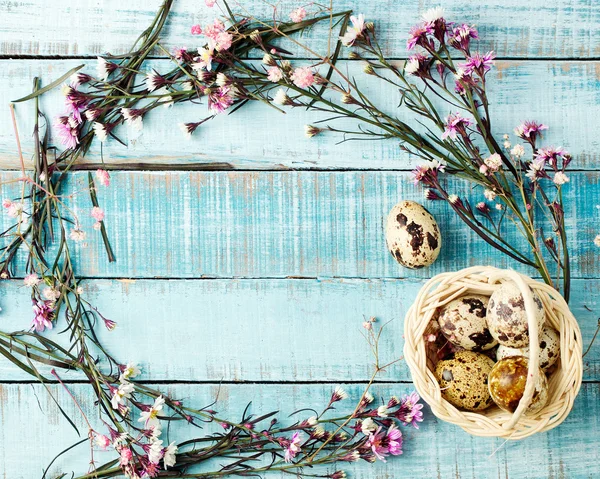 Wachteleier in Rückenlehne und Blumengestell auf blauem Holz — Stockfoto
