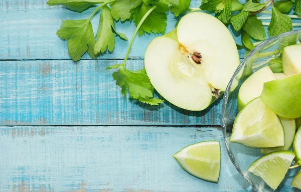 Зеленое яблоко, известь и сельдерей на голубом деревянном столе — стоковое фото