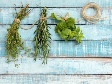 Kekik, biberiye ve nane mavi ahşap üzerinde ip asılı