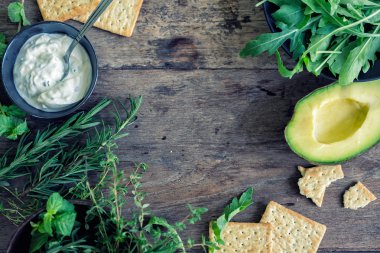 Ahşap üzerine avokado, otlar, kraker ve Cacik