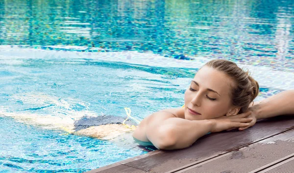 Mujer joven caucásica relajándose en la piscina — Foto de Stock