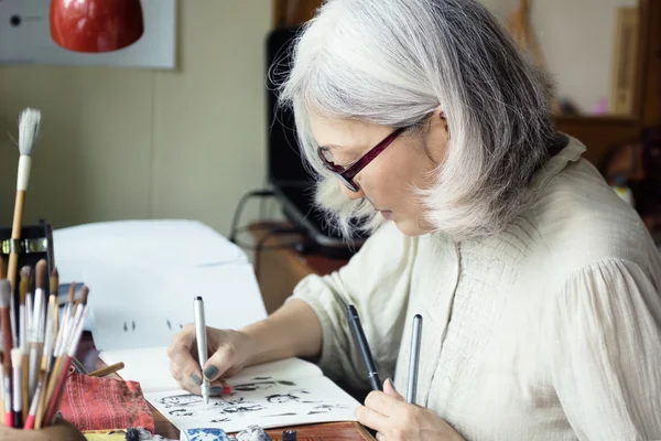 Asian senior woman artist sketching — Stock Photo, Image