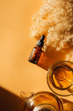 Kahverengi cam şişede bej arka planda yüz yağı
