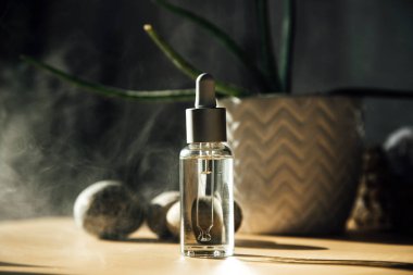 Arka planda sıvı bulunan kozmetik şişesi, kapat