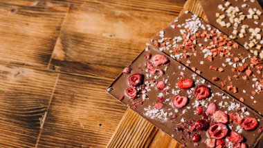 Ahşap arka planda lezzetli çikolatalar.