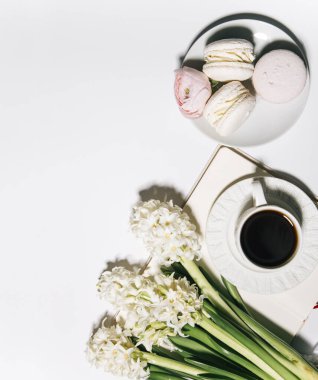 Beyaz arka planda kahve, sümbül ve badem kurabiyesi manzarası.