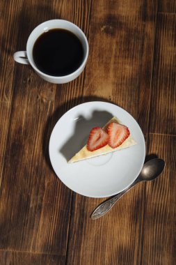 Ormanlık arka planda bir fincan kahveli lezzetli peynirli kek.