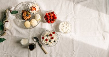 Süzme peynirli, böğürtlenli ve beyaz masadaki keklerden oluşan nefis yemek seti.